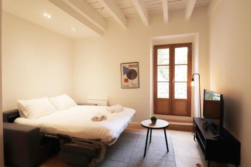 une chambre avec un lit, une télévision et une table dans l'établissement Superbe Appartement au coeur de la vieille ville, à Villefranche-sur-Mer