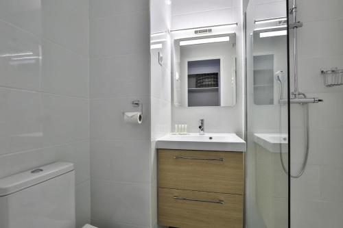 y baño blanco con lavabo y ducha. en Superbe 2 pièce tout confort , PISCINE /AC/PARKING en Villefranche-sur-Mer