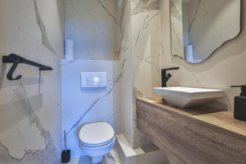 une salle de bain avec des toilettes blanches et un lavabo dans l'établissement Balcon vue Coulée Verte. Luxe Plein cœur de Nice, à Nice