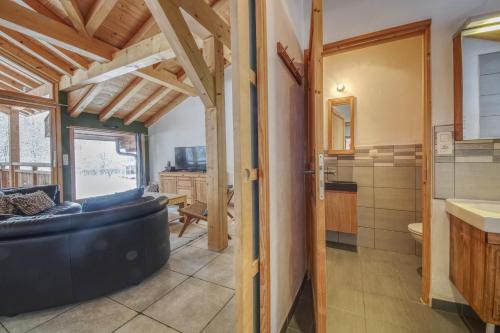 a living room with a large couch and a bathroom at Chalet Minouche in Chamonix-Mont-Blanc