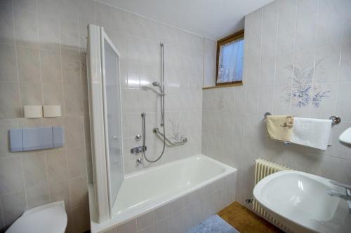 bagno con doccia, vasca e lavandino di Apartment Soval a Ortisei