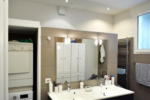 a bathroom with two sinks and a large mirror at Villa - Climatisé -Vue mer - Proximité des plages in Villefranche-sur-Mer