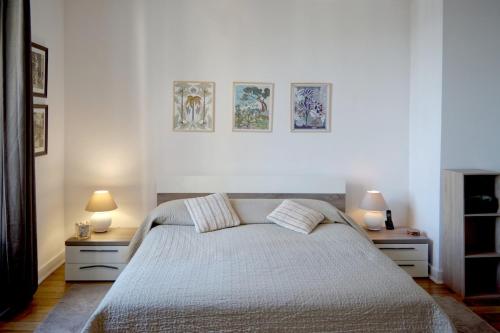 a bedroom with a bed with two night stands and two lamps at Villa - Climatisé -Vue mer - Proximité des plages in Villefranche-sur-Mer