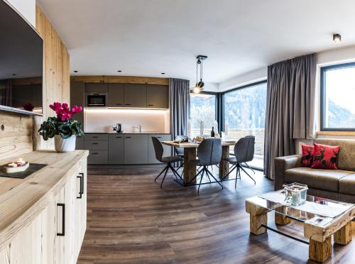 Apartments Grunnes في أورتيساي: مطبخ وغرفة معيشة مع أريكة وطاولة