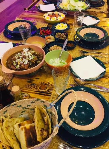 a wooden table with plates of food on it at Dar Khedija in El Kheriba