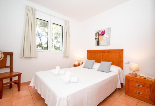 1 dormitorio con 1 cama blanca grande y 2 almohadas en Villa Ermita by Sonne Villas, en Cala Galdana