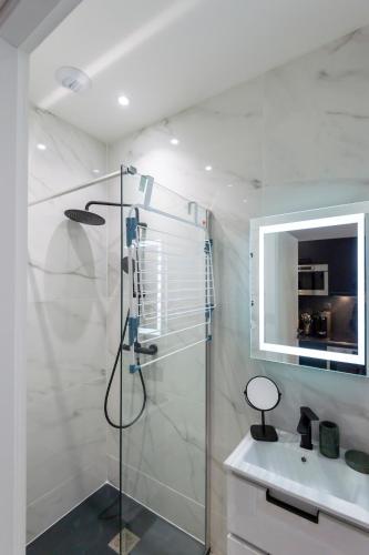 une salle de bain avec une douche en verre et un lavabo dans l'établissement Superbe studio Plage/Promenade des Anglais 105, à Nice