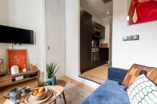 un salon avec un canapé bleu et une table dans l'établissement Superbe studio Plage/Promenade des Anglais 105, à Nice