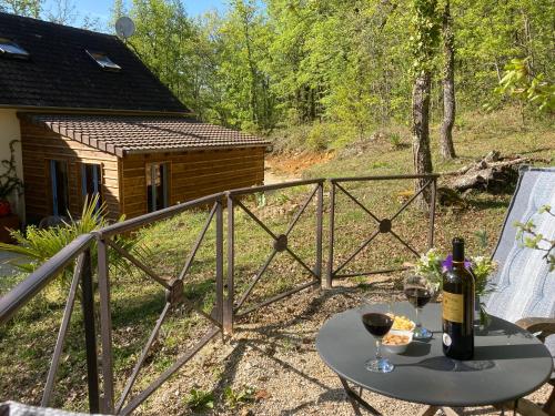 a table with two glasses of wine on a balcony at le bout du Bout in Les Arques