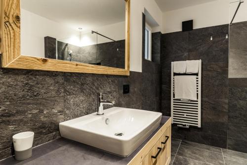 a bathroom with a sink and a mirror at Apartments Grunnes in Ortisei