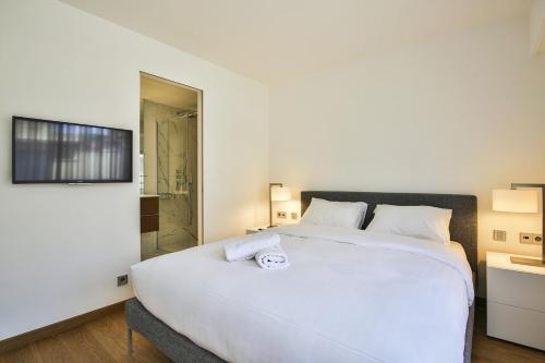 - une chambre avec un grand lit blanc et une douche dans l'établissement Sublime Appartement Promenade des Anglais RDJ, à Nice