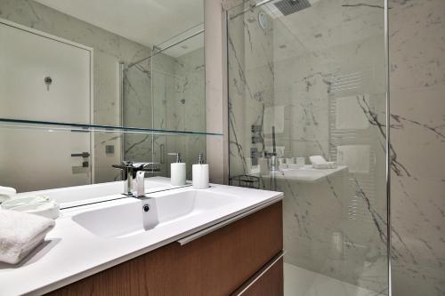 une salle de bain avec un lavabo et une douche en verre dans l'établissement Sublime Appartement Promenade des Anglais RDJ, à Nice