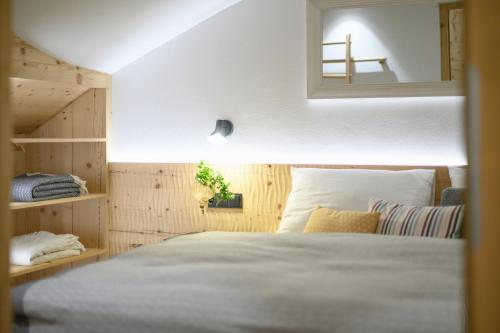 a bedroom with a bed and a mirror at Central Home Apartment in Ortisei