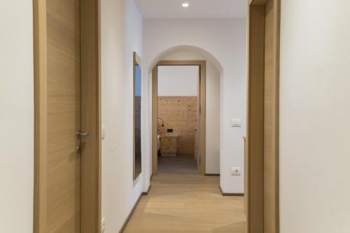 een hal die leidt naar een kamer met een spiegel bij Apartments Jalve in Ortisei