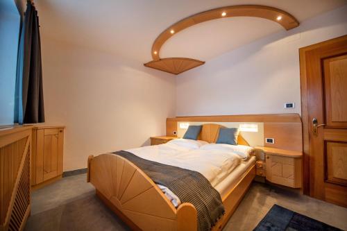 um quarto com uma cama grande e uma luz grande em Apartment Sellablick em Ortisei