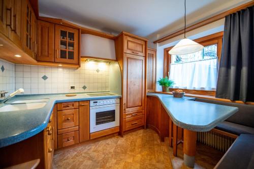 une cuisine avec des placards en bois et un comptoir bleu dans l'établissement Apartment Sellablick, à Ortisei