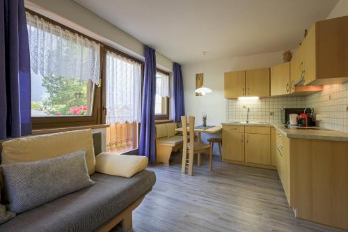 ein Wohnzimmer mit einem Sofa und einer Küche in der Unterkunft Apartments Woerndle in Seis am Schlern