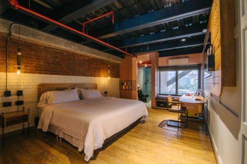 Un pat sau paturi într-o cameră la The Somos Beats Hotel & Rooftop