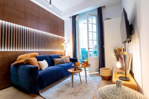 a living room with a blue couch in a room at Superbe studio balcon Plage/ Prom. des Anglais 103 in Nice