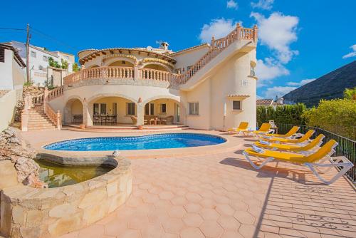 a villa with a swimming pool and some chairs at Villa Claudia - PlusHolidays in Benitachell