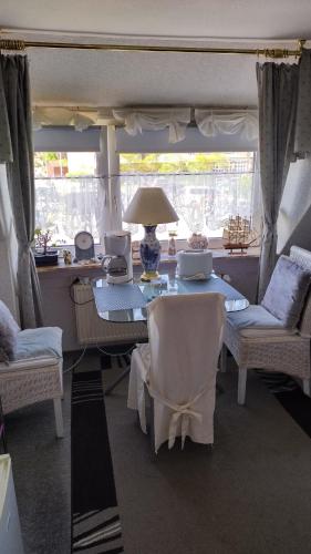 a dining room with a table and chairs and a window at Sonnendeich in Norddeich