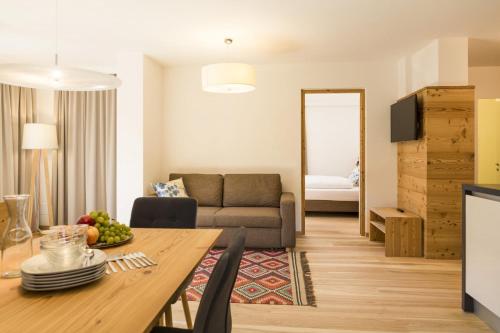 - un salon avec une table et un canapé dans l'établissement Residence Luzerna ***, à Selva di Val Gardena