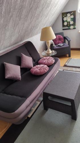 a black couch with pink pillows in a living room at Sonnendeich in Norddeich