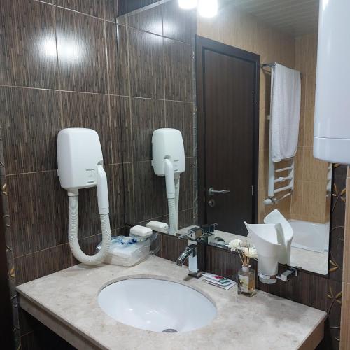 un baño con lavabo y espejo en Комплекс Александьр между Банско и село Бяня, en Bansko