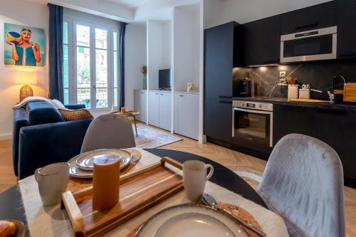 une cuisine et un salon avec une table et des chaises dans l'établissement Superbe 2P Plage/ Promenade des Anglais 203, à Nice