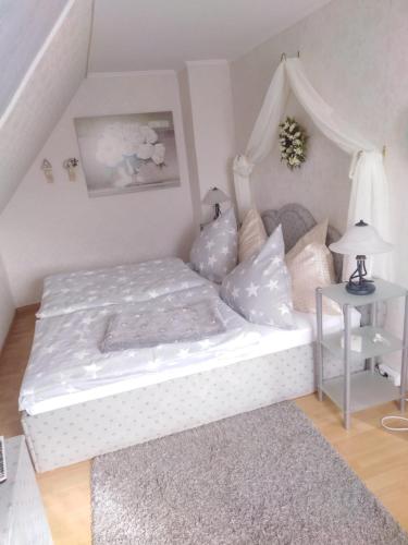 a bedroom with a white bed and a table at Sonnendeich in Norddeich