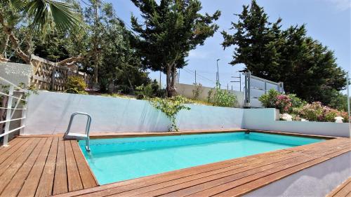 een zwembad op een houten terras naast een hek bij La piccola casa di Cinzia in Alcamo