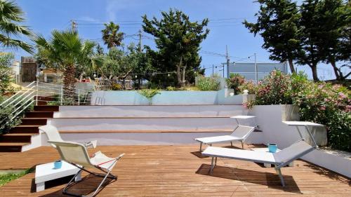 een patio met witte stoelen en een trap bij La piccola casa di Cinzia in Alcamo