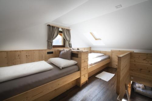 two beds in a room with wooden cabinets at Apartments Rondula in Santa Cristina Gherdëina
