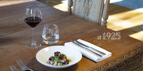 a wooden table with a plate of food and a glass of wine at Hotel De Diane in Sables-dʼOr-les-Pins