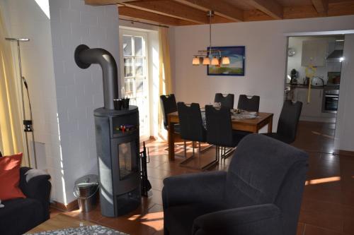 a living room with a wood stove and a dining room at Kapitänskoje in Greetsiel