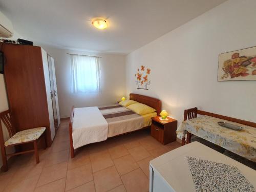 ein kleines Schlafzimmer mit einem Bett, einem Tisch und einem Tisch in der Unterkunft ELENA, 100 m from the beach in Novigrad Istria