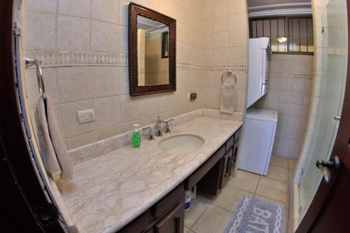 a bathroom with a sink and a mirror at Presidential Suites 4 - Recently renovated 2 bedroom condominium in the heart of Flamingo in Playa Flamingo