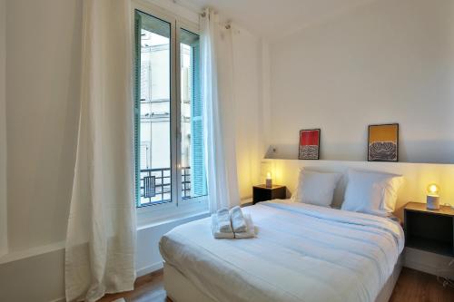 a white bedroom with a bed and a window at Place Massena - Beau 2P/Wifi - Vieux Nice/Plage in Nice