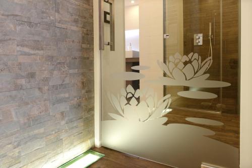 een kamer met een glazen deur met bloemen erop bij Apartments Mujnei in Santa Cristina in Val Gardena