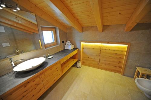 ein Bad mit einem Waschbecken und einem Spiegel in der Unterkunft Mountain Apartment Hapeli in St. Ulrich in Gröden