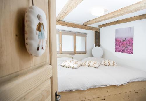 - une chambre avec un lit doté de draps et d'oreillers blancs dans l'établissement Rain Apartment with private spa area-Zorten-Lenzerheide, à Obervaz