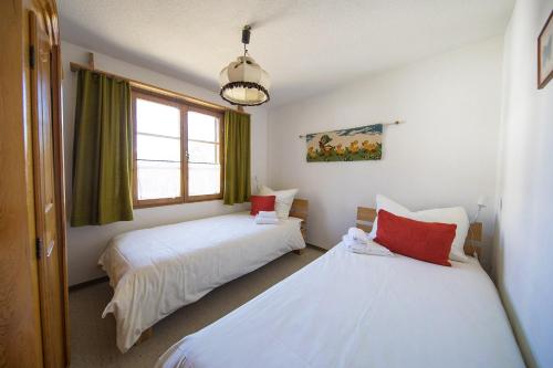 a bedroom with two beds and a window at Ferienhaus Alvaneu für Familien in Alvaneu