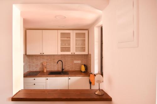 a kitchen with white cabinets and a sink at Penzion Marcipánka in Třeboň