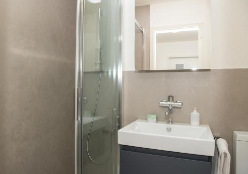 uma casa de banho com um lavatório e um chuveiro em Central flat Crapera-Lenzerheide em Lenzerheide