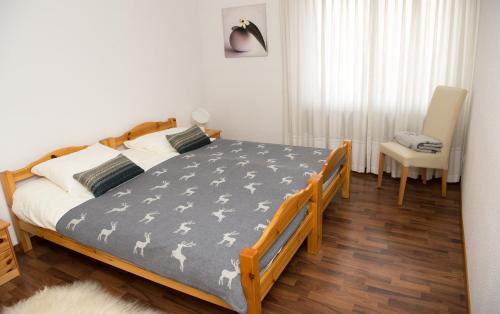 - une chambre avec un lit et une chaise dans l'établissement Central flat Crapera-Lenzerheide, à Lenzerheide