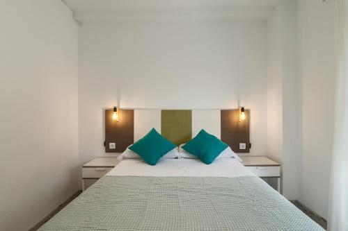1 dormitorio con 1 cama grande con almohadas azules en C91 - Two Bedroom apartment next to Alcazaba, en Málaga