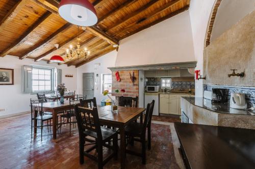 a kitchen and dining room with a table and chairs at Casa António Moreira in Óbidos