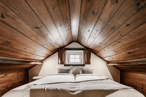 Cama grande en habitación con techo de madera en Country Village Senses, en Reguengo Grande