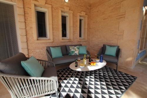 een patio met banken en een tafel en stoelen bij Chalet Mediterráneo Bolnuevo by Rental Olé in Puerto de Mazarrón