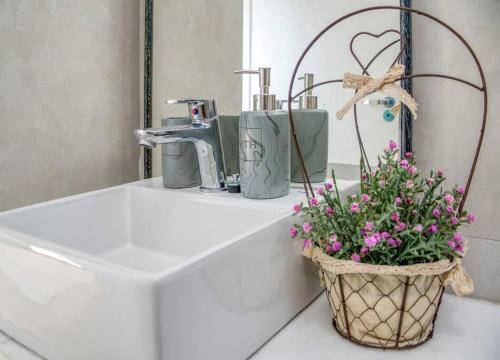 Una cesta de flores sentada en un lavabo en el baño. en A estrenar! Apartamento con pileta zona aeropuerto WIFI 200MG en La Mercedes